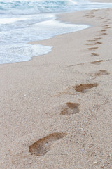 Footprints on the sandy beach, sea waves, nature background
