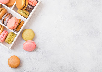 Dessert cake macaron or macaroon in white wooden box on stone kitchen table background . Top view. Space for text.