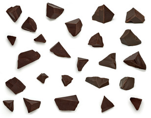 Broken, cracked or crushed dark chocolate parts from top view isolated on white background