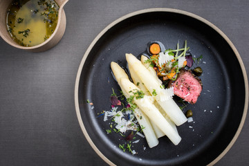 Modern Style classic white asparagus with barbecue dry aged sliced beef fillet and vegetable served...