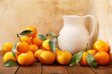 Fresh mandarin oranges fruit or tangerines with leaves on wooden table