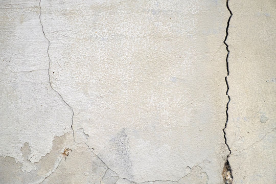 Old Foundation And Plaster Wall With Cracks. Building Requiring Repair Closeup.