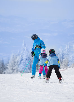 Children with teacher learning skiing
