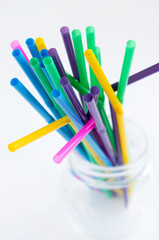 Colorful drinking straws in mason jar on white background