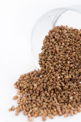 Buckwheat groats in a glass on white background