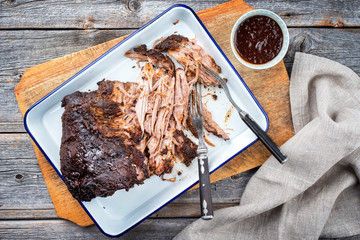 Traditional barbecue pulled pork piece of Bosten butt torn to bits as top view on a board