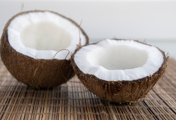 Halves of fresh coconut on a wooden surface