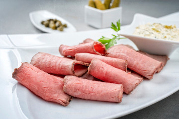 Traditionelles Brotzeit ufschnitt mit Rostbraten und Remoulade als closeup auf einem weißen Teller