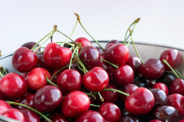 Lots of fresh ripe black cherries in colander. Closeup.
