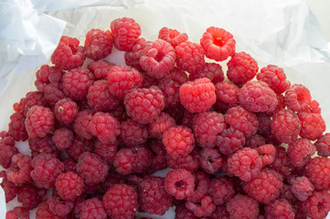Pile of fresh raw raspberries on white background.