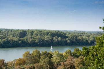 White river boat sailing the Danube under the clear blue sky, between Kalemegdan park and the woods...