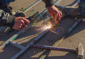 welder working on the street making a hedge