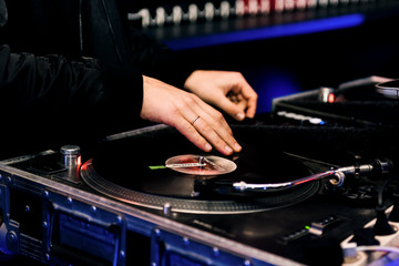 Party dj plays music at hip hop concert.Turntables vinyl record player.Retro analog audio equipment...
