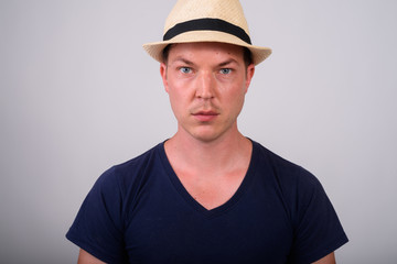 Close up of young handsome tourist man wearing hat against