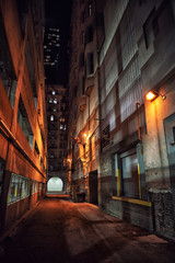 Fototapeta na wymiar Dark and eerie downtown urban city alley with a loading dock nex