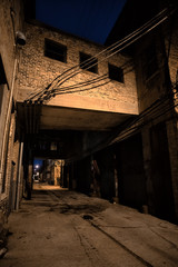 Fototapeta na wymiar Dark and scary downtown urban city street alley scene with an ee