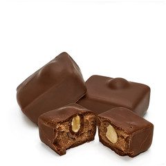 Broken chocolate blocks and cracked pieces with hazelnuts or filberts isolated on white background