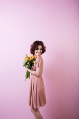 Young happy woman with a bouquet of flowers tulips.