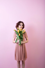 Young happy woman with a bouquet of flowers tulips.