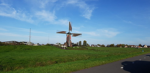 Fototapeta na wymiar Old historical windmills in the Doespolder at Hoogmade in the Netherlands running with sails on its wings