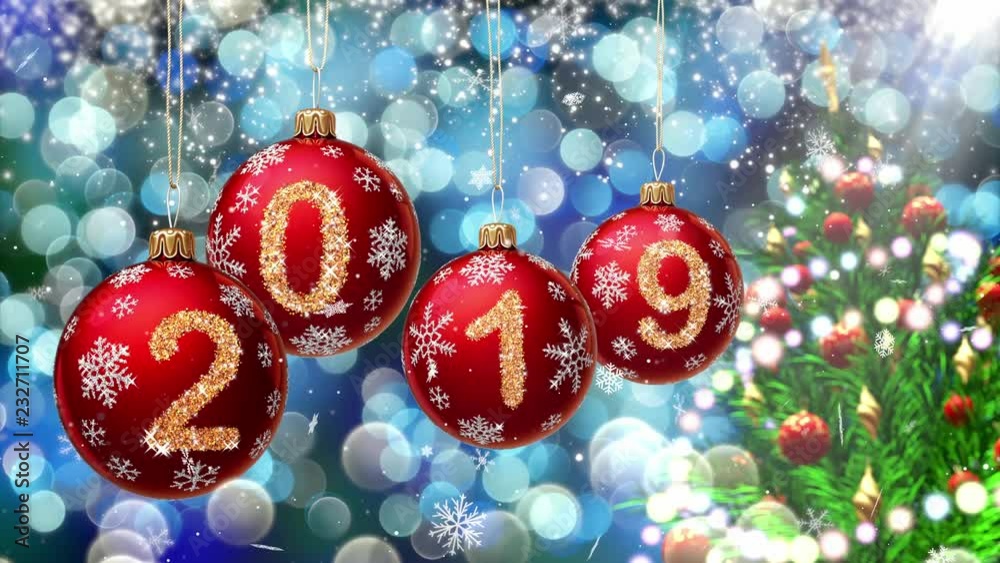 Wall mural red balls with numbers 2019 hanging on the background of a blue bokeh and a rotating christmas tree 