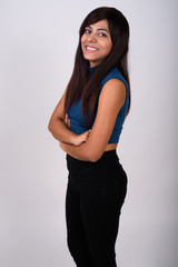 Naklejka premium Studio shot of young happy Persian woman smiling and standing wi