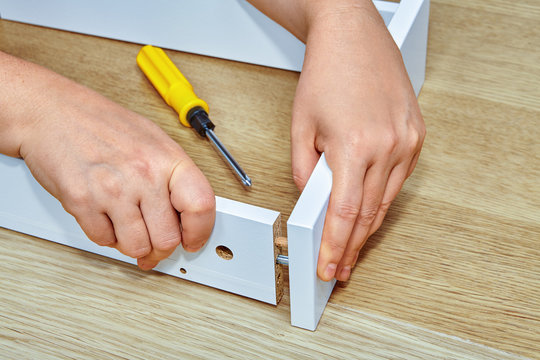 Furniture assembler joins together two parts of  furniture.