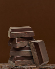 Dark chocolate bars stack isolated on brown background