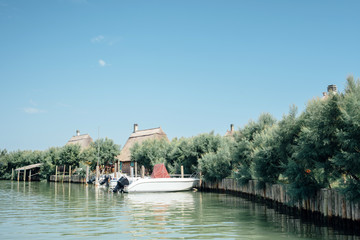 Caorle, Venice lagoon Italy. Boats moored in front of the characteristic "casoni".