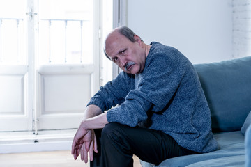 Fototapeta premium Depressed overwhelmed old man feeling exhausted alone and unhappy suffering from depression