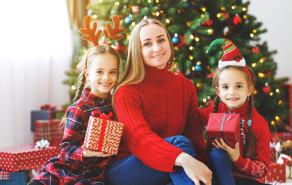 family   mother and children open presents on Christmas morning