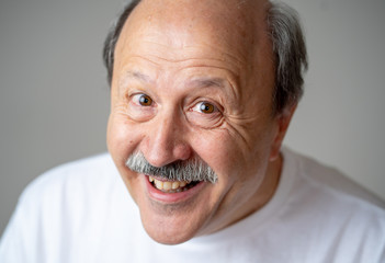 Close up portrait of smiling senior man with happy face looking at the camera