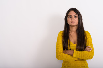 Studio shot of young Indian woman with arms crossed against whit © Ranta Images