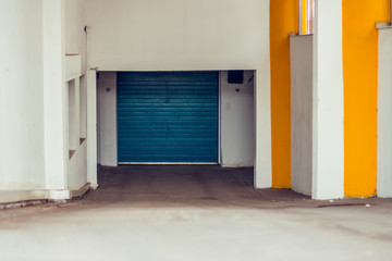 Underground garage entrance with white walls and yellow pillars