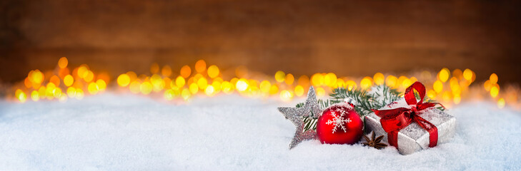 weihnachtsgeschenk dekoration Christbaumkugel rot silber schnee bokeh lichterhintergrund /...
