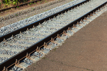 Railroad tracks with concrete sleepers. Detailed image of a railway track with gravel dumping and a...