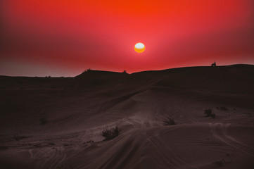 Fototapeta na wymiar Motorrad auf einer Dühne in der Wüste bei Sonnenuntergang