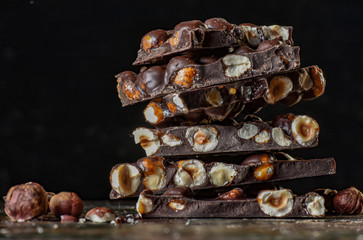 Chocolate tower with cocoa and nuts, chocolate culinary background. Handmade chocolate pieces with spices.