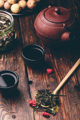 Tea bowls with teapot and spoonful of raspberry herbal tea