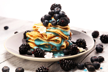 Delicious Tasty Homemade crepes or pancakes with blackberries,blueberries and blue spirulina nicecream.