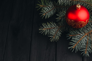 Christmas New Year decoration composition. Top view of fur-tree branches and balls frame on wooden background with place for your text. close up