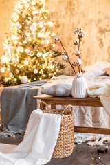 vase with cotton branches. Loft style apartments, Christmas tree. Bed in the bedroom, high large Windows