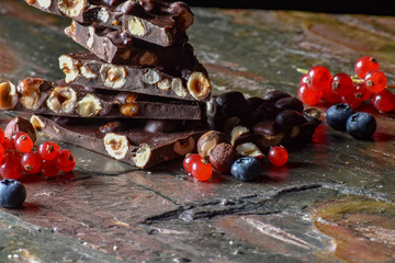 Berries and chocolate on the stone and black background