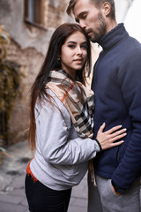 Portrait of a young romantic couple hugging during the city walk at the warm autumn day. Two lovers are walking and hugging in Lviv, Ukraine