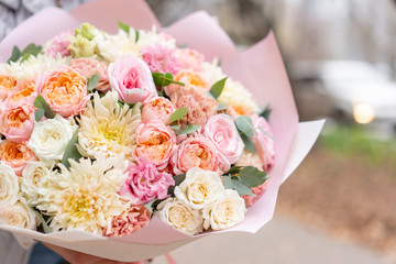 Beautiful spring bouquet in woman hand. Arrangement with various flowers. The concept of a flower shop. A set of photos for a site or catalogue. Work florist.