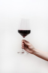 hand with glass of red wine