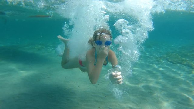 A little girl jumping off of the sup into the sea in slow motion