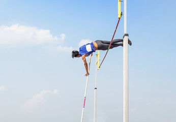 athlete pole vault pole jumping competition over bar in to the sky at stadium
