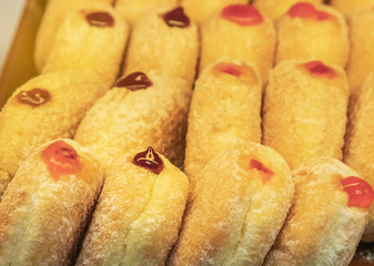 Close up row of sweet golden donuts with jam 