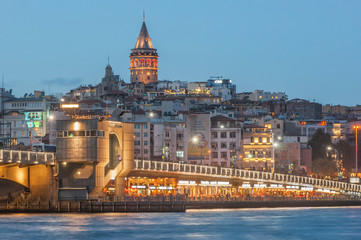 Fototapeta premium Galata Tower and Galata Bridge with lots of fish restaurant at night scene on Golden Horn Eminonu which is famous tourist area Istanbul, Turkey